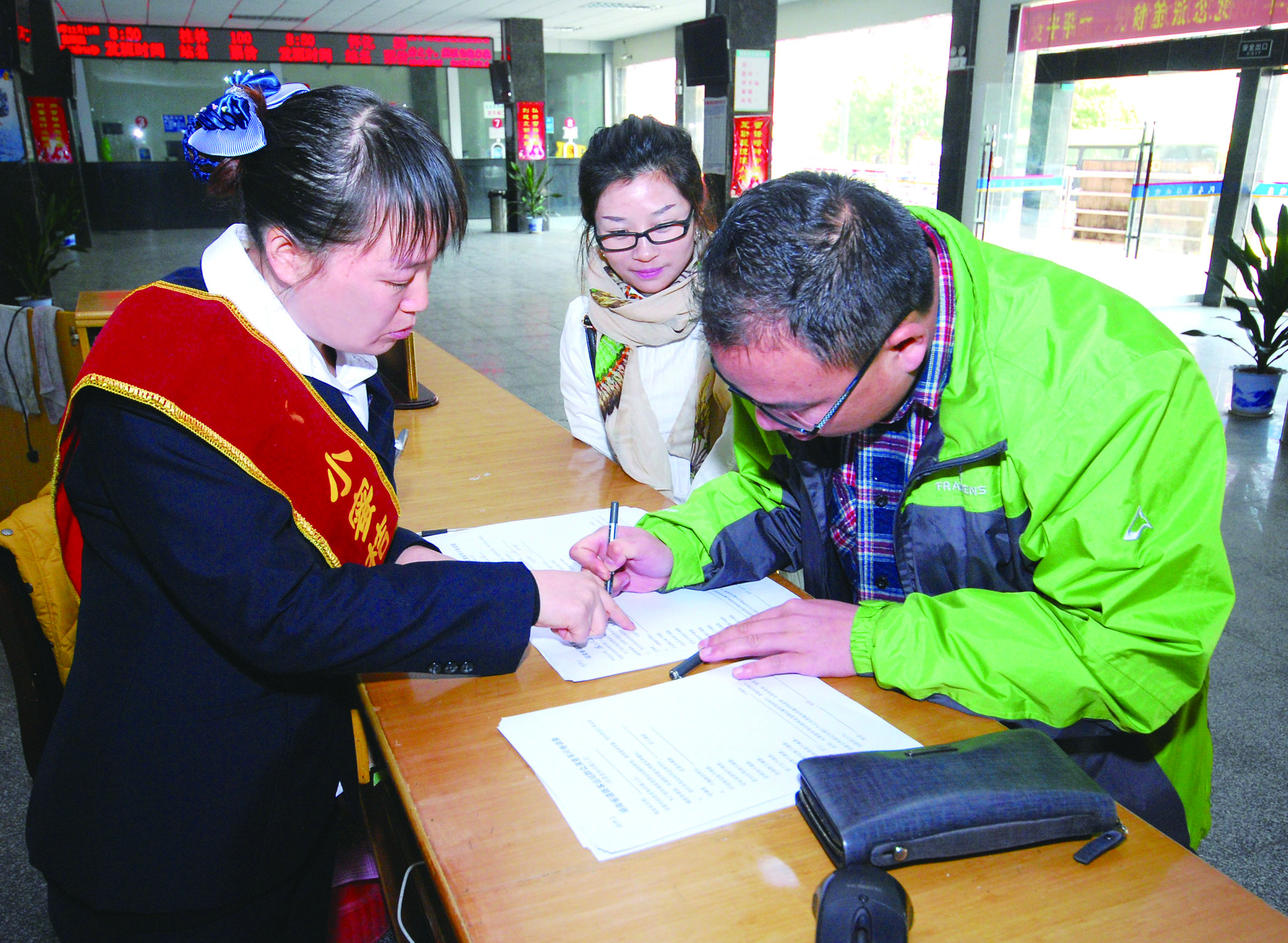 圖為洞口汽車總站站務(wù)人員在熱心為旅客服務(wù)。